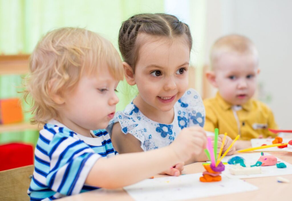 Young children making playdough sculptures at a table